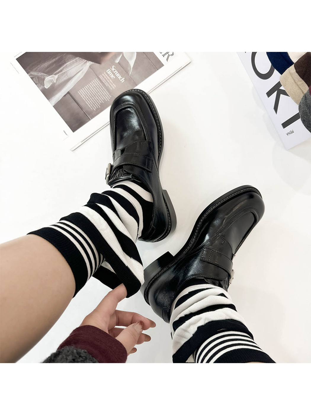 Black and white striped layered crew socks worn with black loafers
