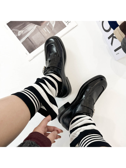 Black and white striped layered crew socks worn with black loafers