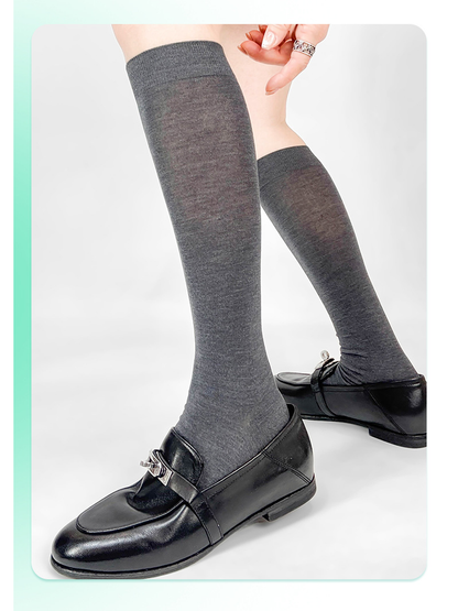 Dark gray knee-high socks styled with black loafers