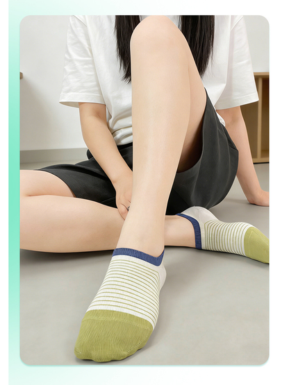 Green and white striped no-show socks worn while seated