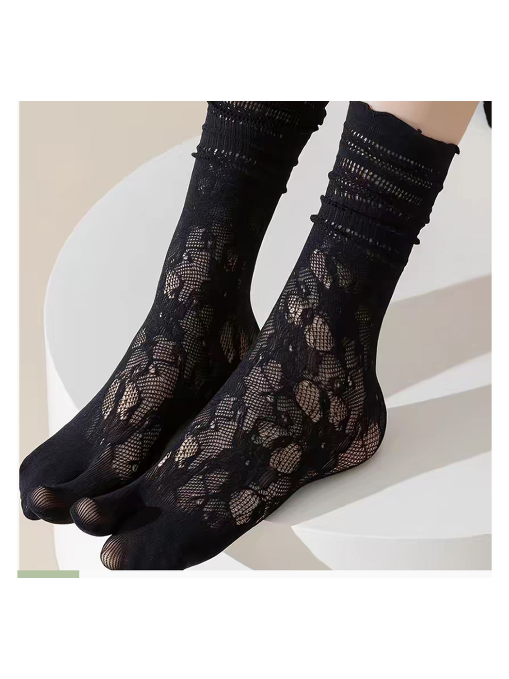 Close-up of black floral openwork socks and separated toes