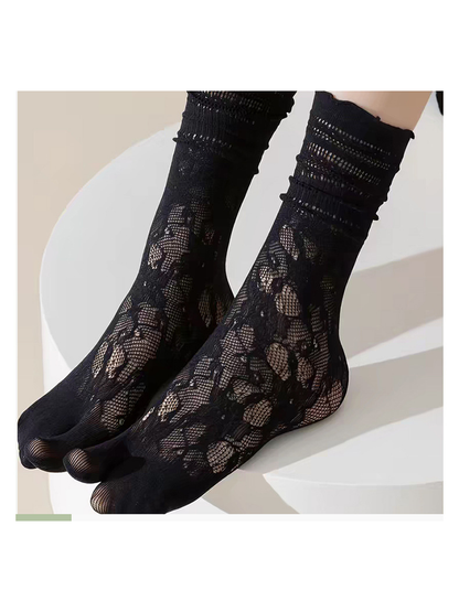 Close-up of black floral openwork socks and separated toes