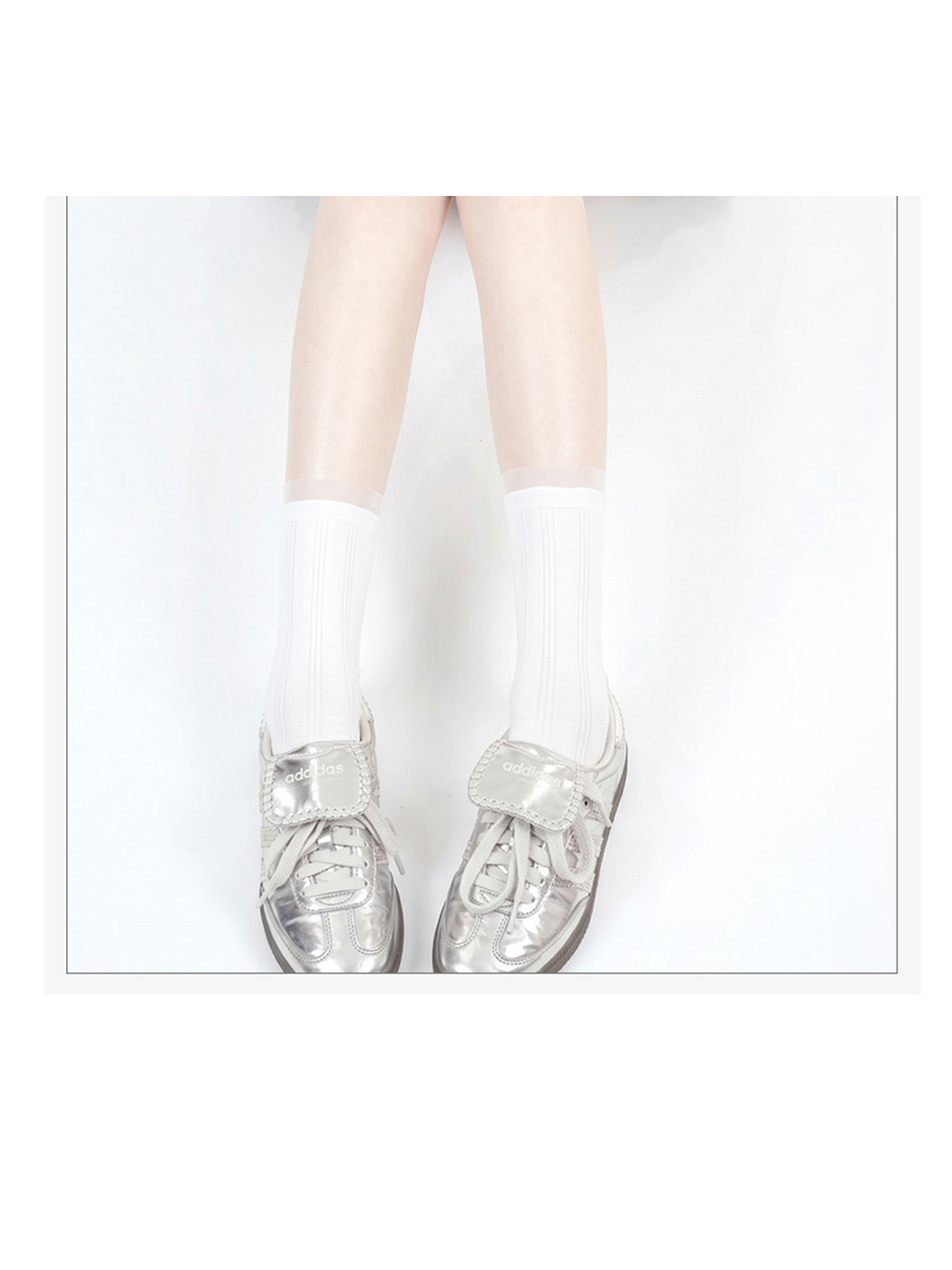 White sheer striped crew socks worn with silver sneakers, front view