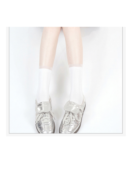 White sheer striped crew socks worn with silver sneakers, front view