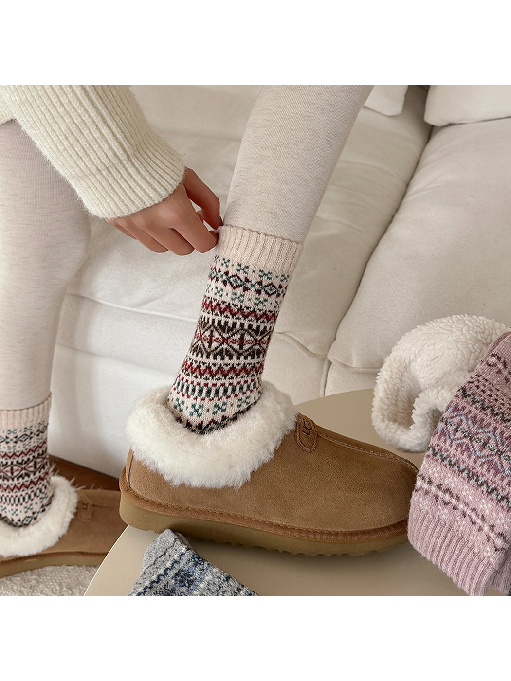 Ivory geometric crew socks worn with fuzzy-lined slippers