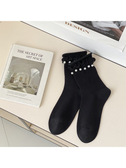 Black ruffled crew socks with white bead-like cuff accents