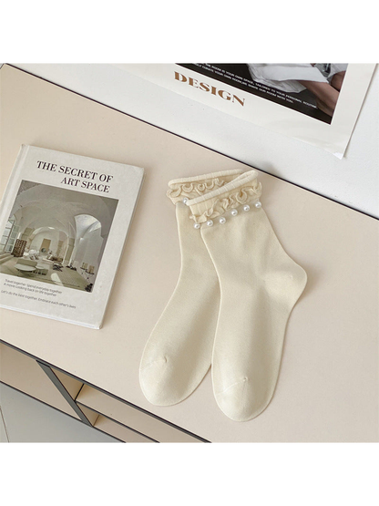 Ivory ruffled crew socks with white bead-like cuff accents