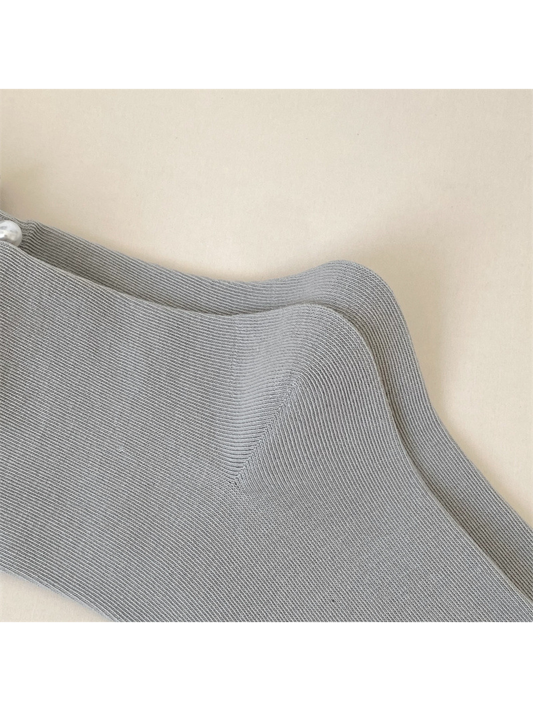 Close-up of the shaped heel construction on light gray socks