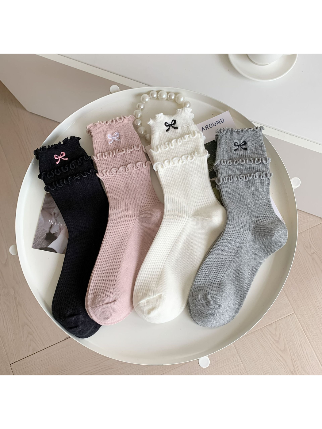 Pink, ivory, gray and black ruffled crew socks displayed together