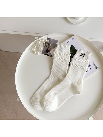 Ivory ruffled crew socks with black embroidered bow