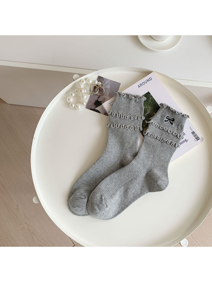 Heather gray ruffled crew socks with black embroidered bow