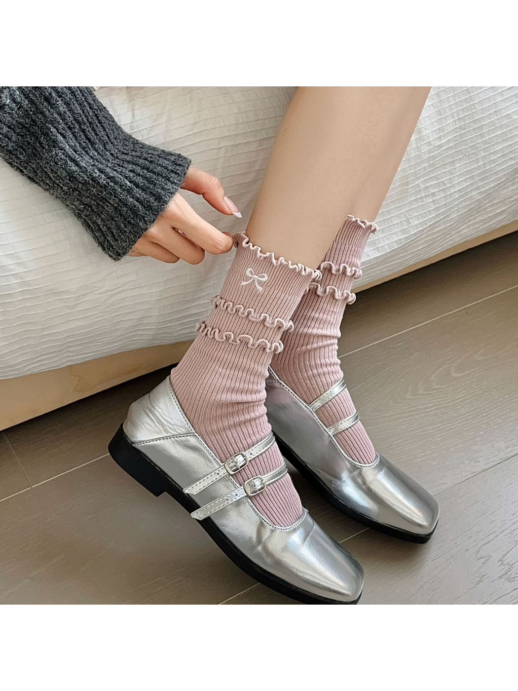 Dusty pink ruffled socks worn with silver strap shoes