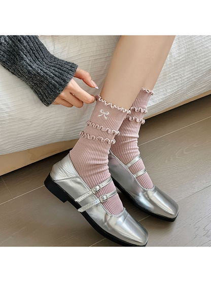 Dusty pink ruffled socks worn with silver strap shoes