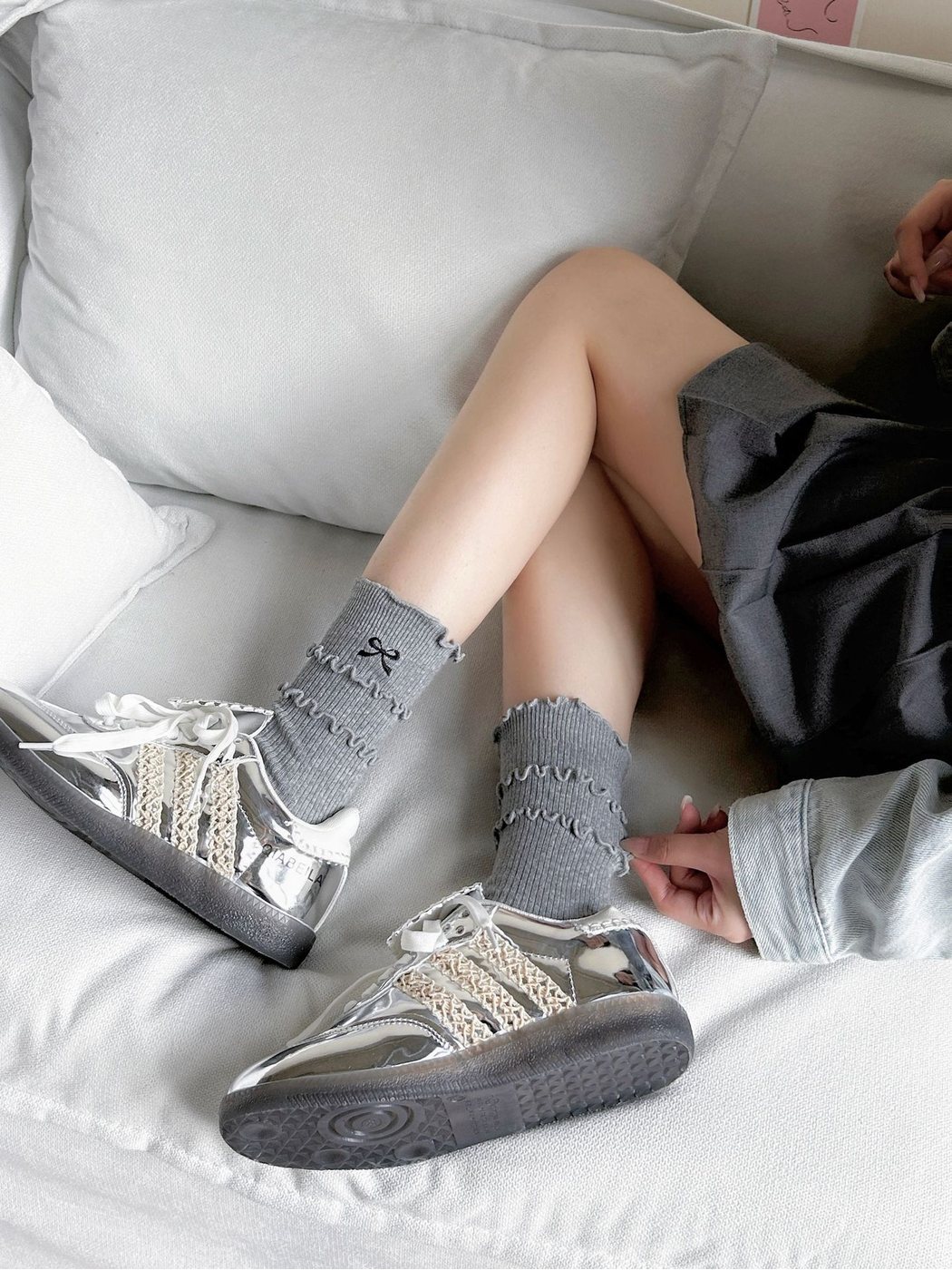 Heather gray ruffled bow socks styled with silver sneakers
