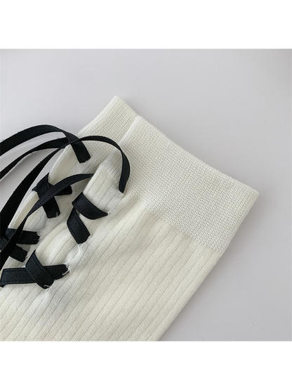 Close-up of the ribbed ivory cuff and black ribbon loops