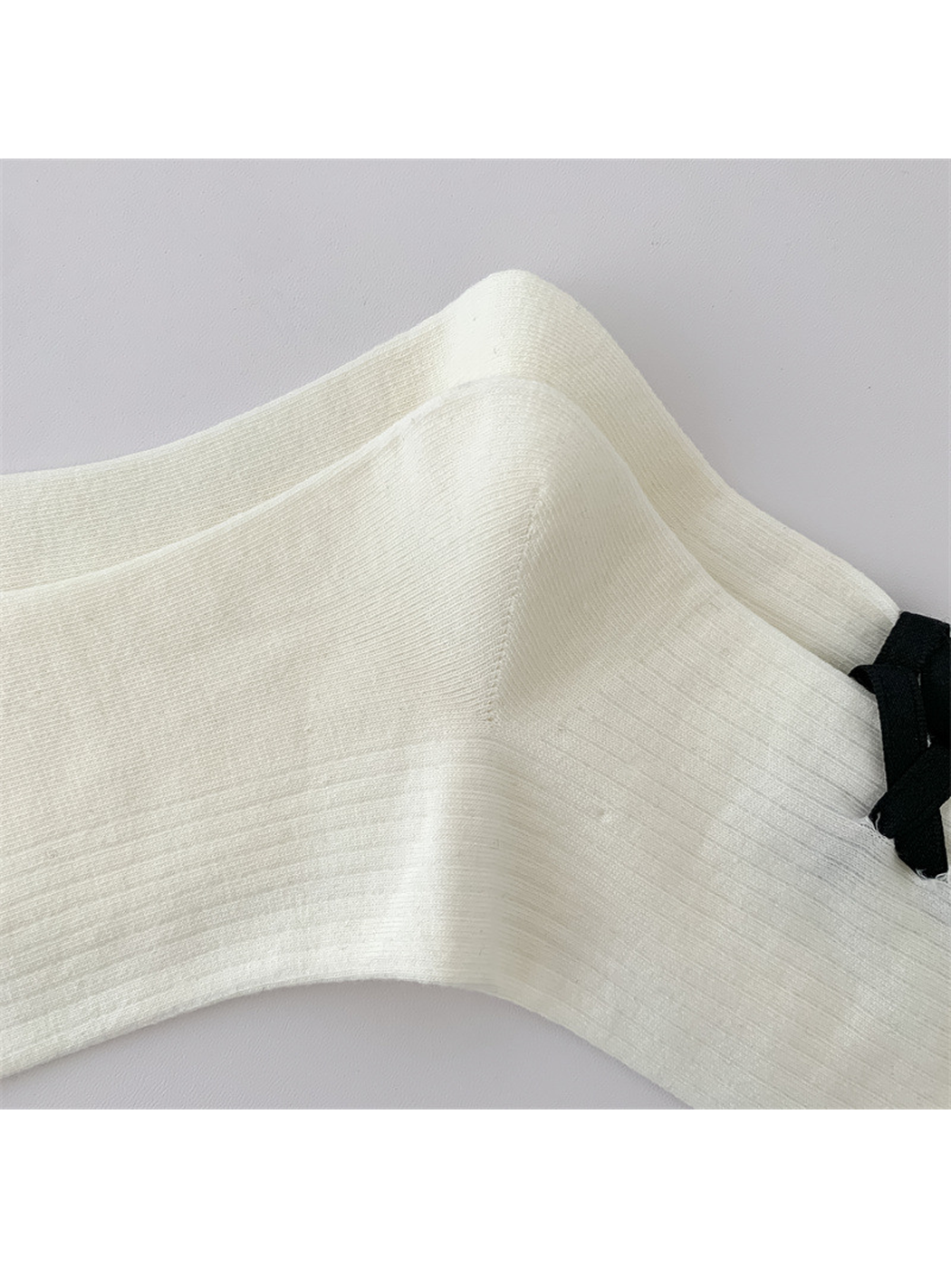 Close-up of the ivory sock's fine vertical ribbing
