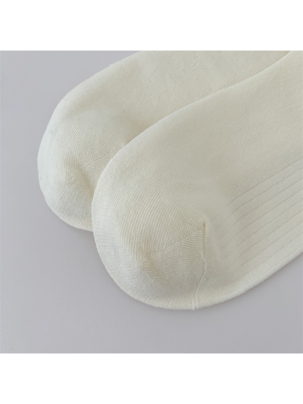 Close-up of the rounded toes and curved seams on ivory socks