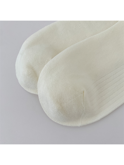 Close-up of the rounded toes and curved seams on ivory socks
