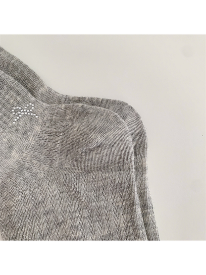 Close-up of the heather gray sock's shaped heel panel and pointelle texture