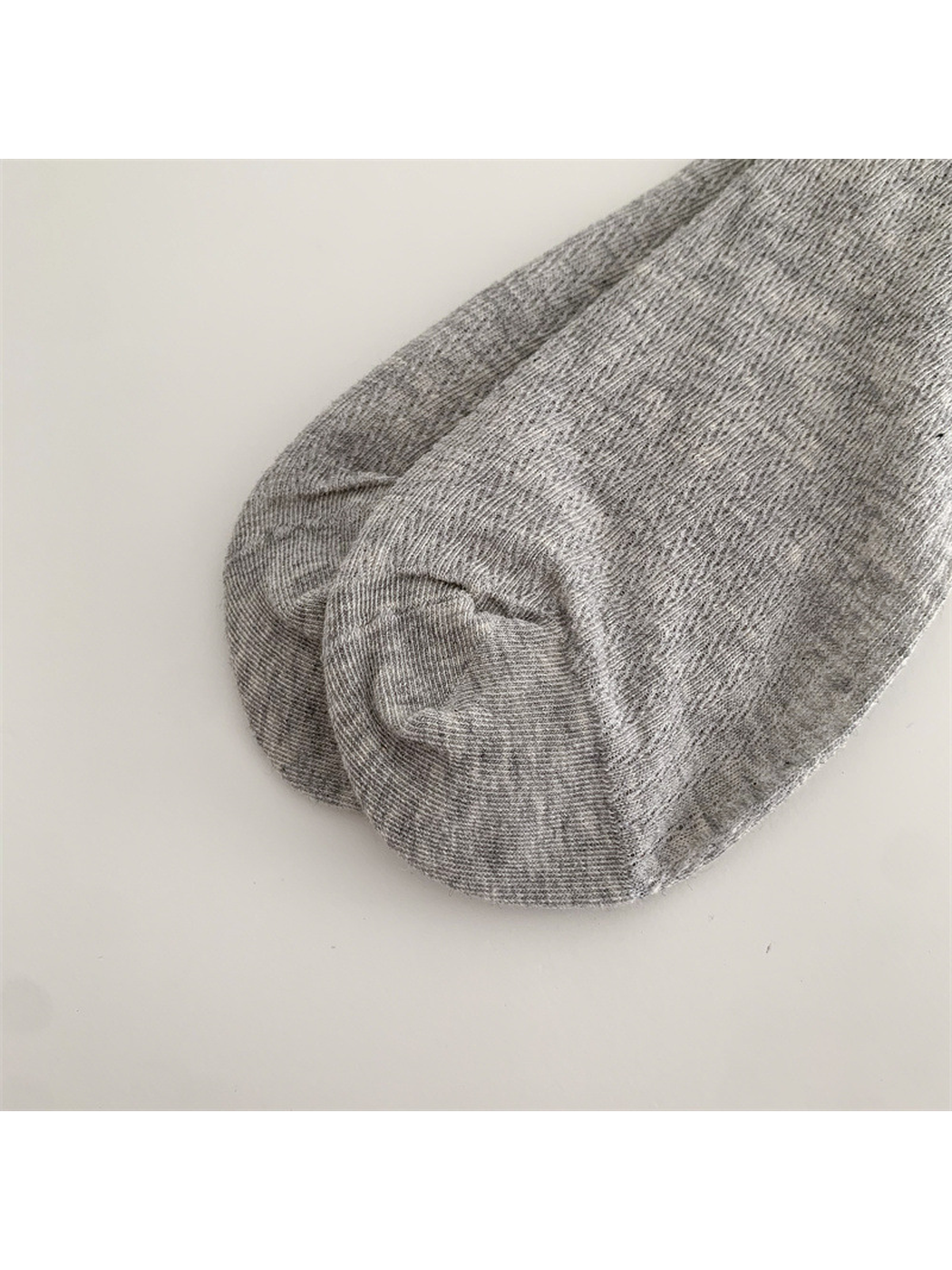 Close-up of the heather gray sock's rounded toe seam