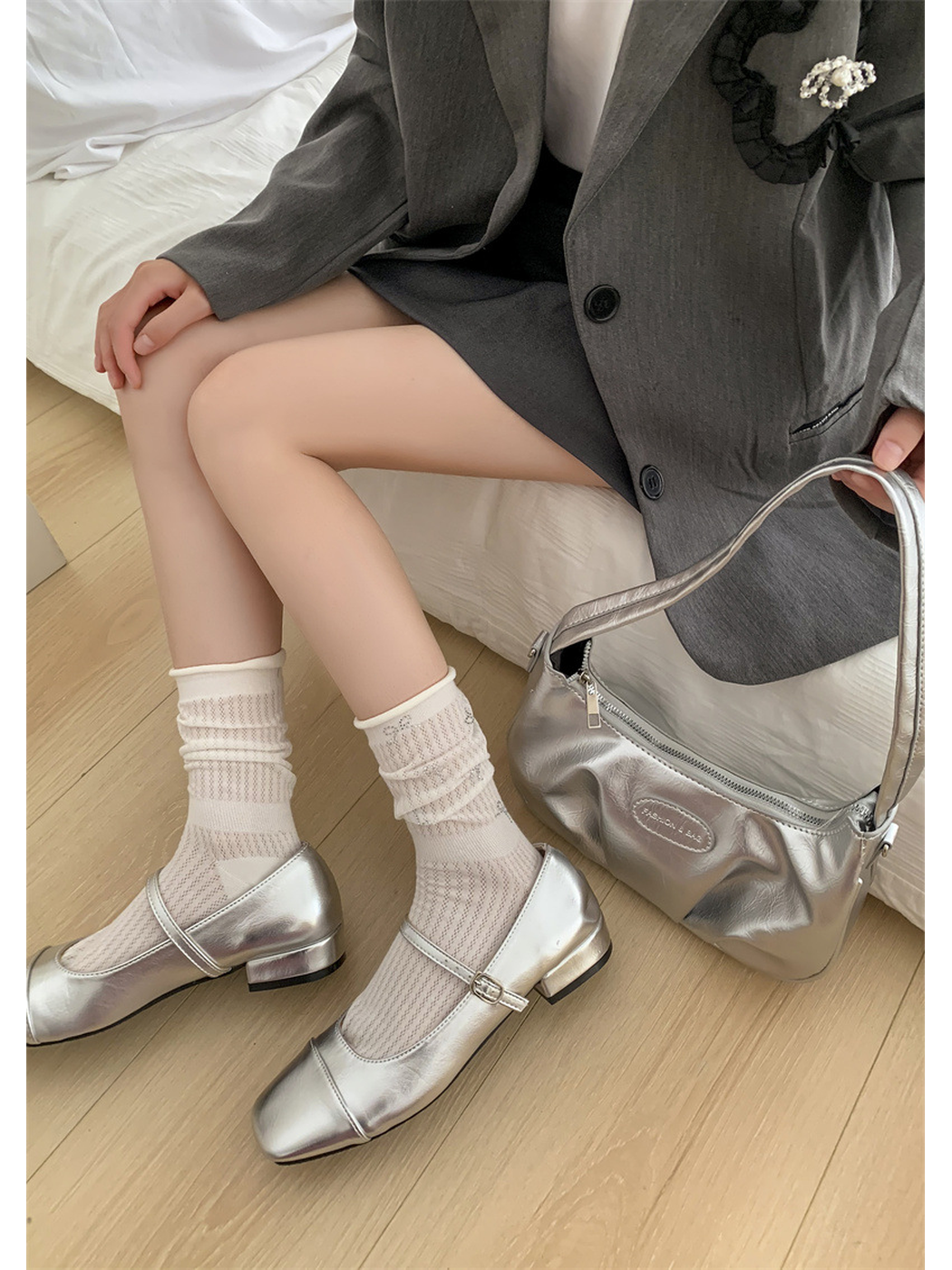 White pointelle crew socks styled with silver Mary Jane shoes