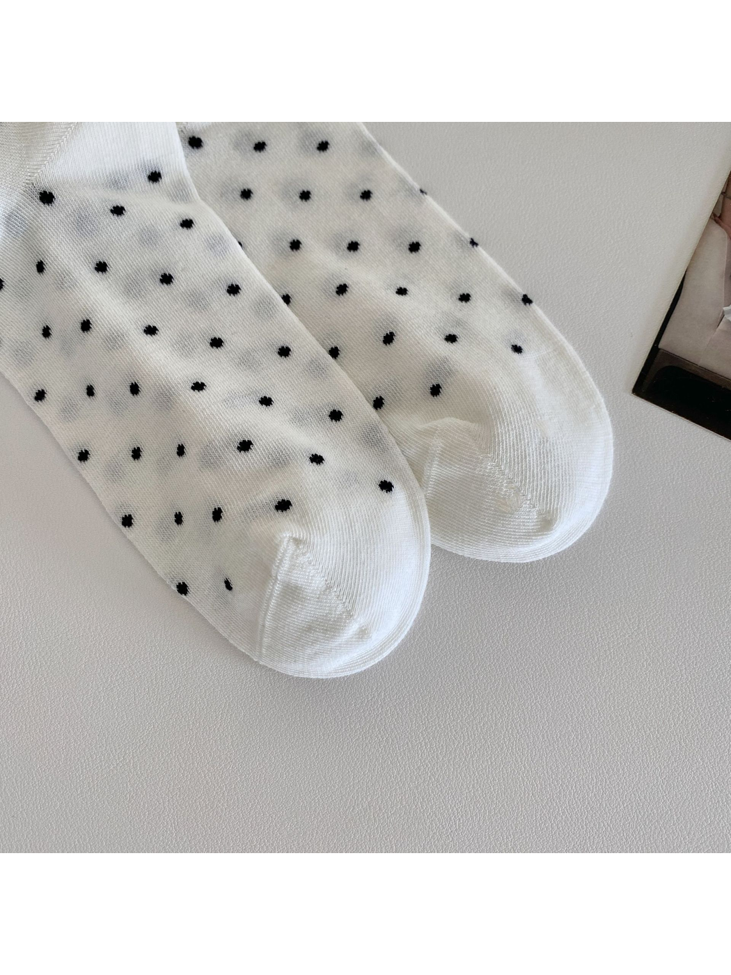 Close-up of the white polka-dot socks' rounded toe panels