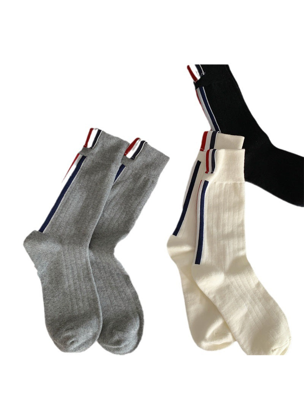 Gray and ivory striped crew socks with a partial black pair on a white background