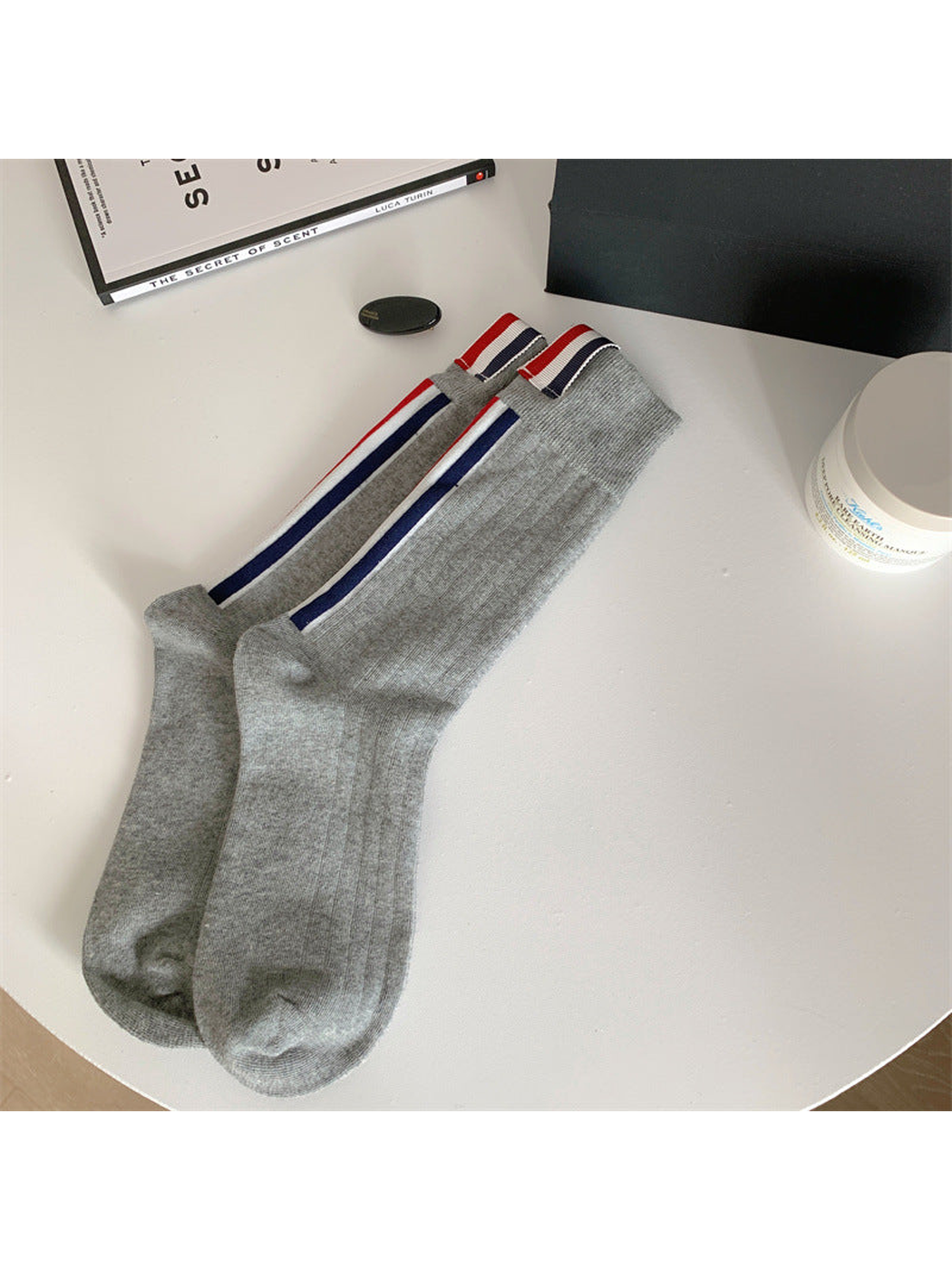 Gray crew socks with navy side stripes and striped cuff tabs