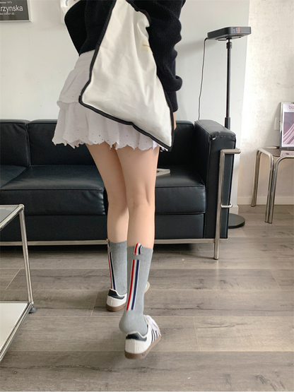 Gray crew socks from the back, showing vertical red, white and navy stripes