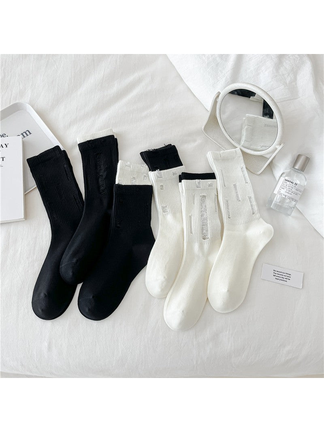 Black and ivory distressed ribbed crew socks displayed together