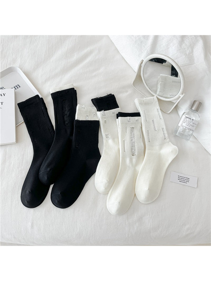 Black and ivory distressed ribbed crew socks displayed together
