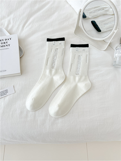 Ivory distressed crew socks with narrow black trim, flat lay