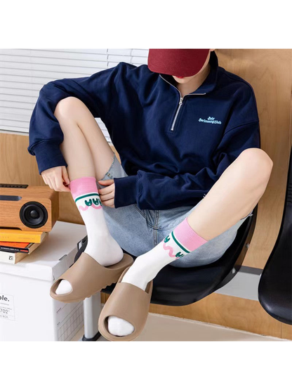 White rabbit-motif crew socks worn with beige slides