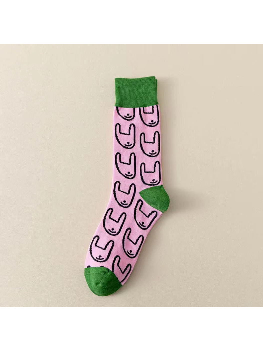 Pink crew sock with green trim and repeating rabbit outlines