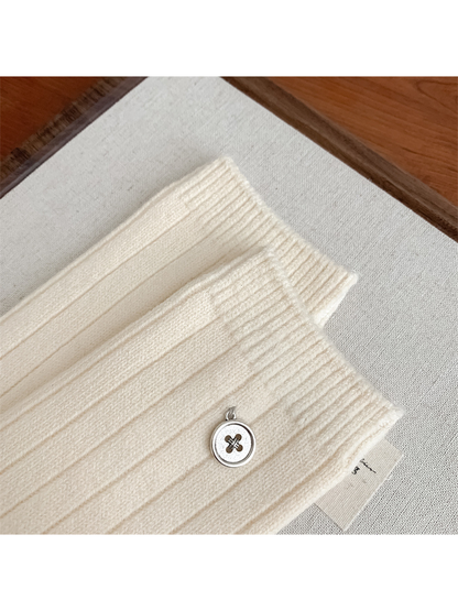 Close-up of the ribbed cuff and round button charm