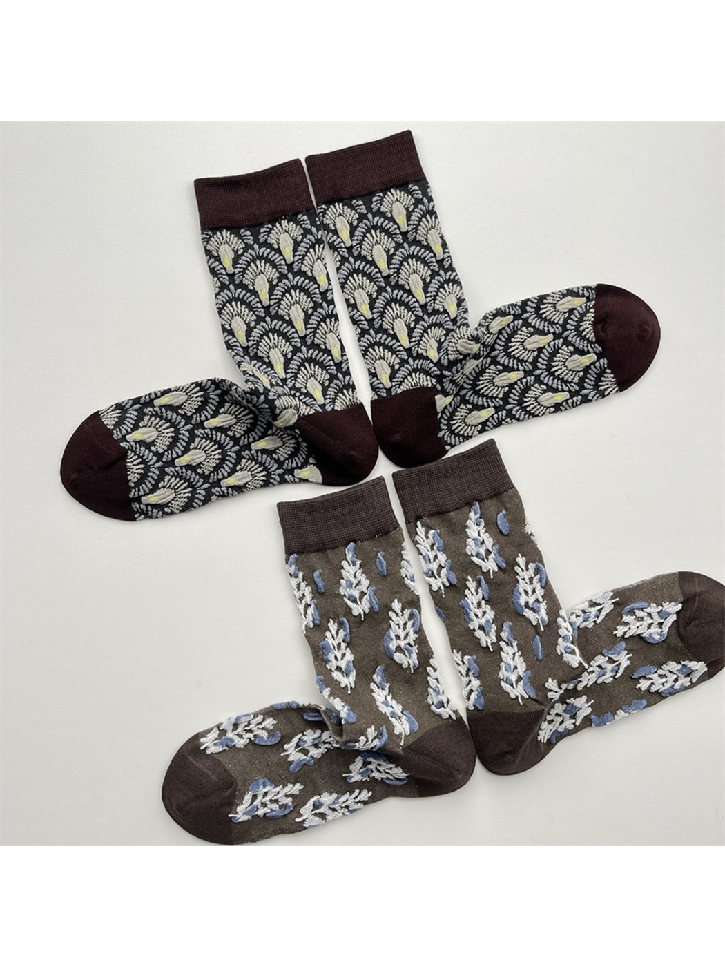 Black fan-pattern and gray botanical-pattern crew socks displayed in pairs