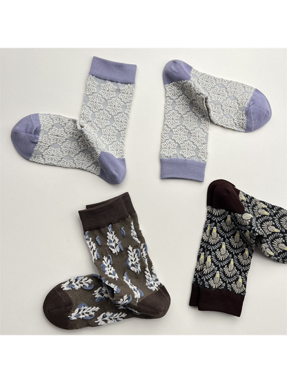 Three patterned crew sock designs arranged in a spaced flat lay