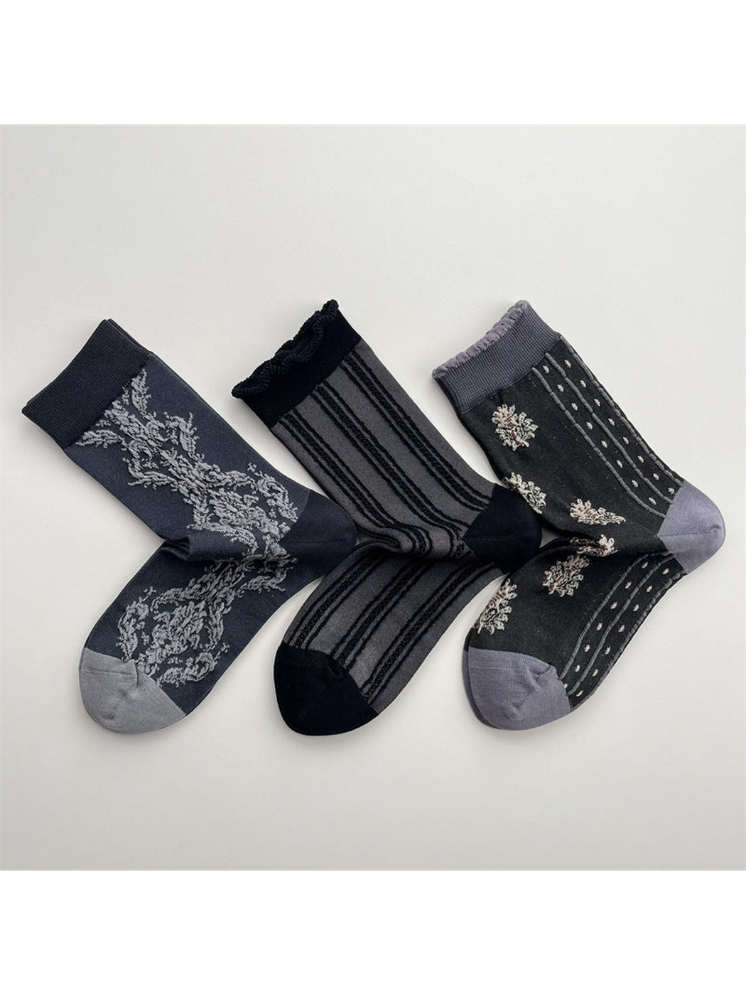 Three dark gray crew sock patterns arranged on a light background