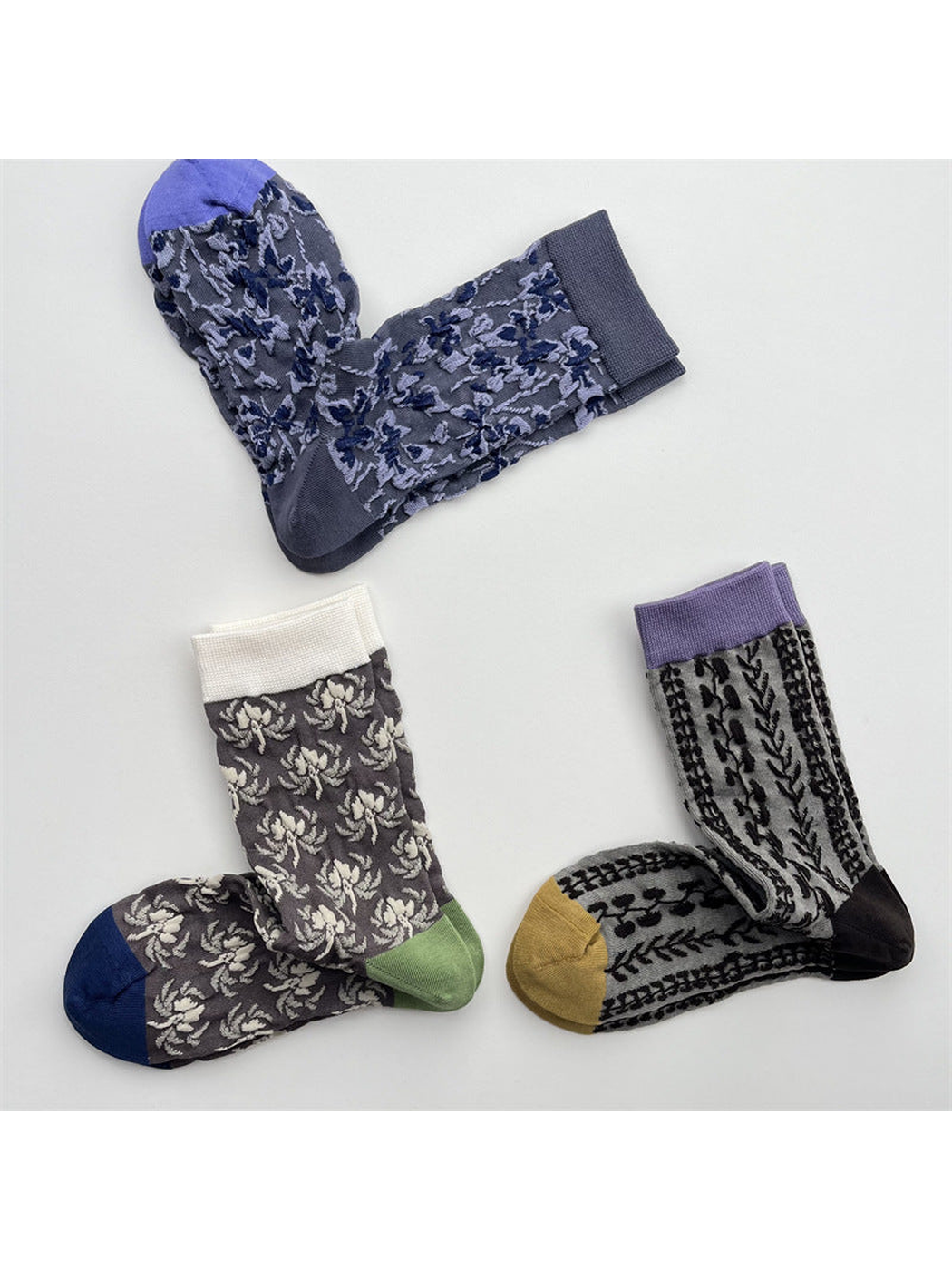 Three patterned crew sock styles displayed separately on a light background