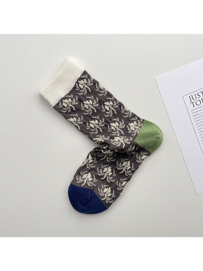 Charcoal-gray floral crew socks with an ivory cuff, green heel and navy toe