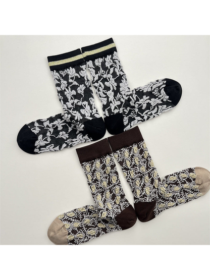 Black floral and dark brown medallion crew socks arranged in pairs
