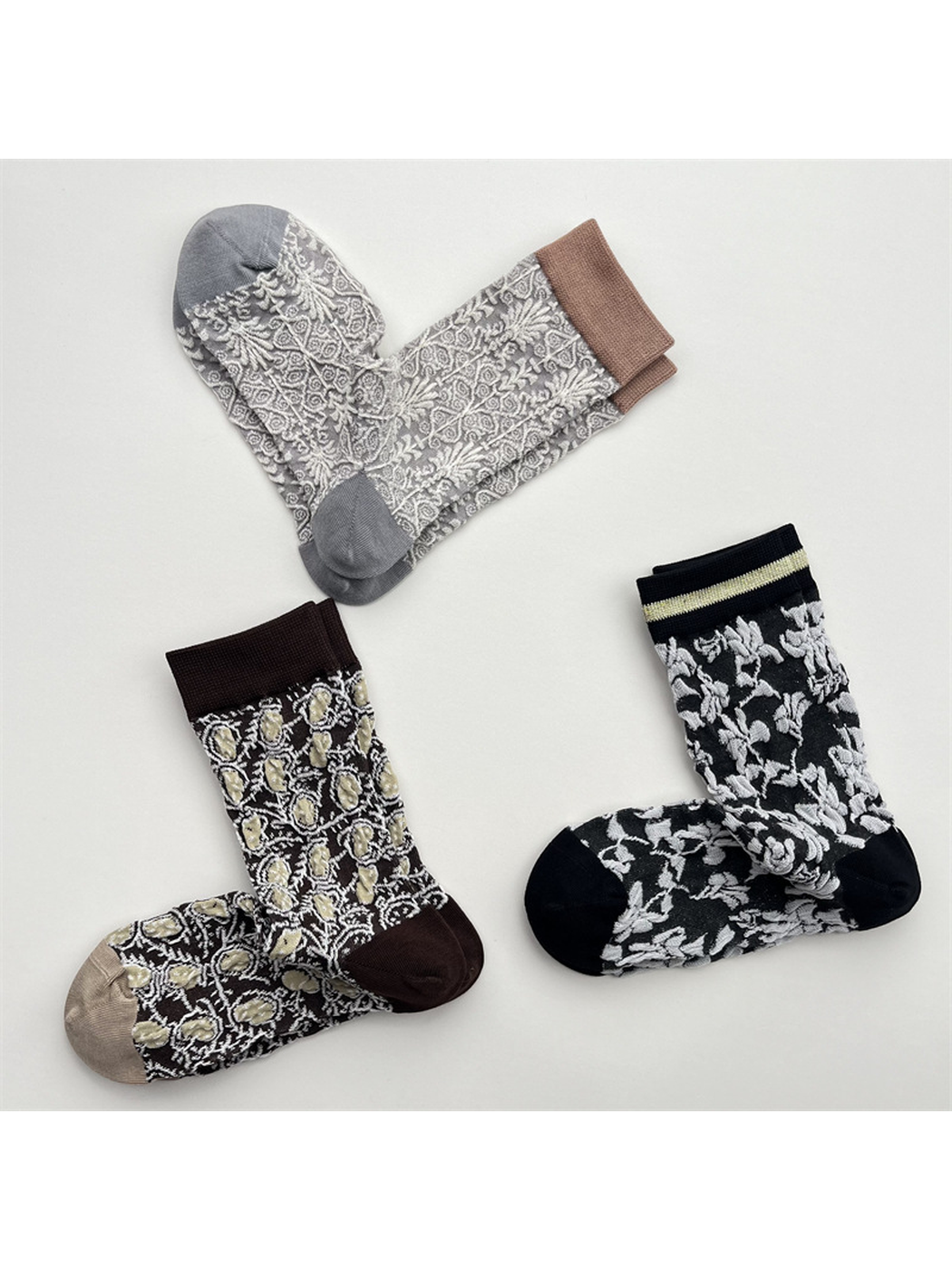 Dark brown, light gray and black patterned crew socks in an overhead arrangement