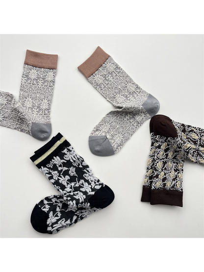 Light gray, black and dark brown patterned crew socks arranged from alternate angles