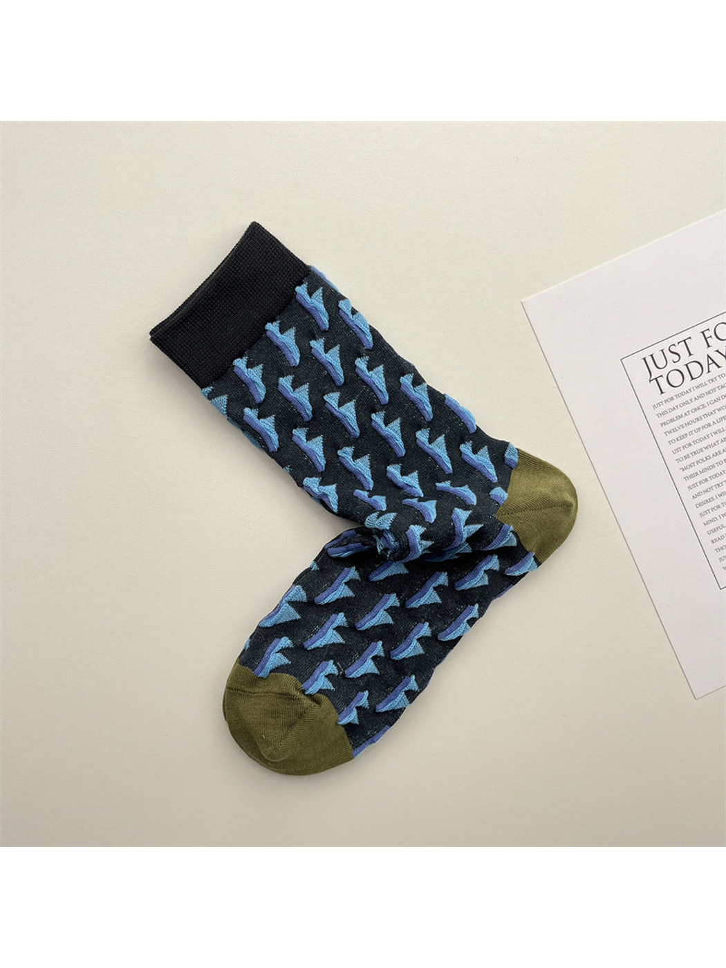 Navy crew socks with repeating blue triangle motifs and olive toes