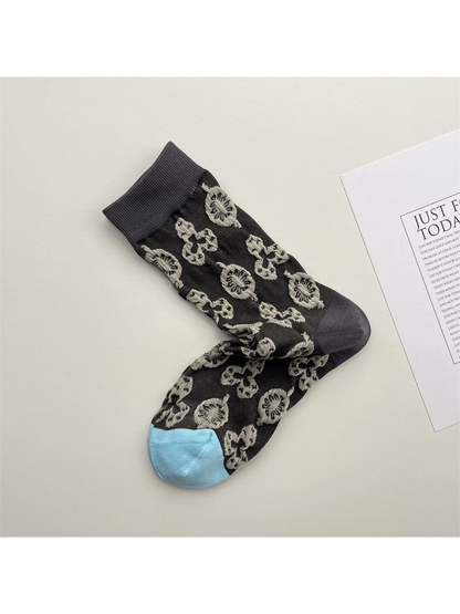 Dark gray-brown crew socks with beige floral motifs and a light blue toe
