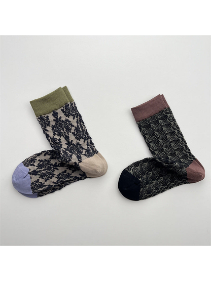 Beige floral and black leaf-pattern crew socks displayed side by side