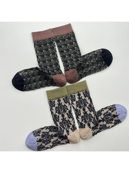 Two pairs of sheer patterned crew socks arranged to show contrasting cuffs and toes