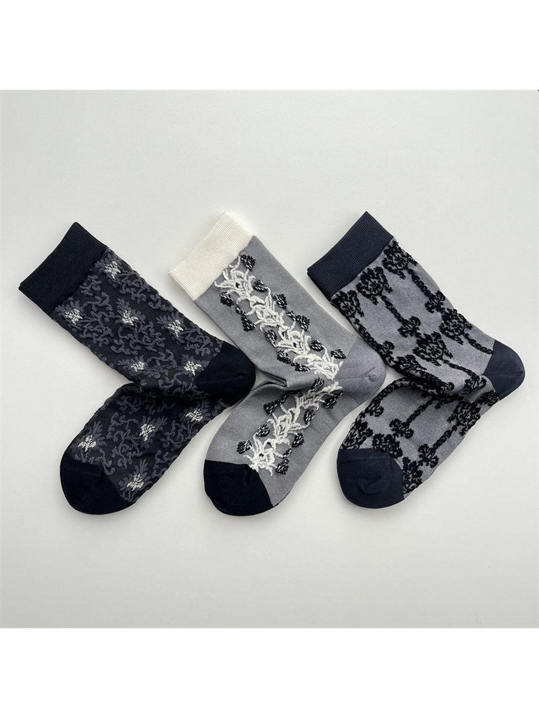 Three gray patterned crew sock designs arranged together