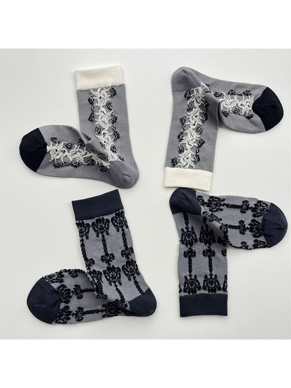 Gray vine-panel and black damask crew socks displayed in pairs