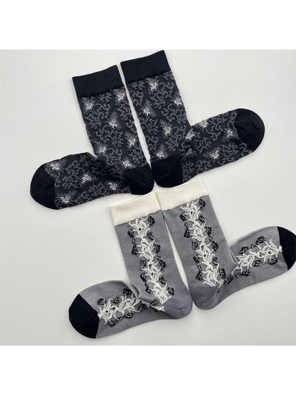 Dark gray floral and gray vine-panel crew socks arranged in two groups